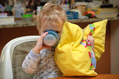 Morning comforts in hand--a warm sippy cup of cocoa and his pillow