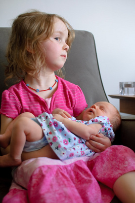 Sitting very still so her new cousin Elsa can sleep